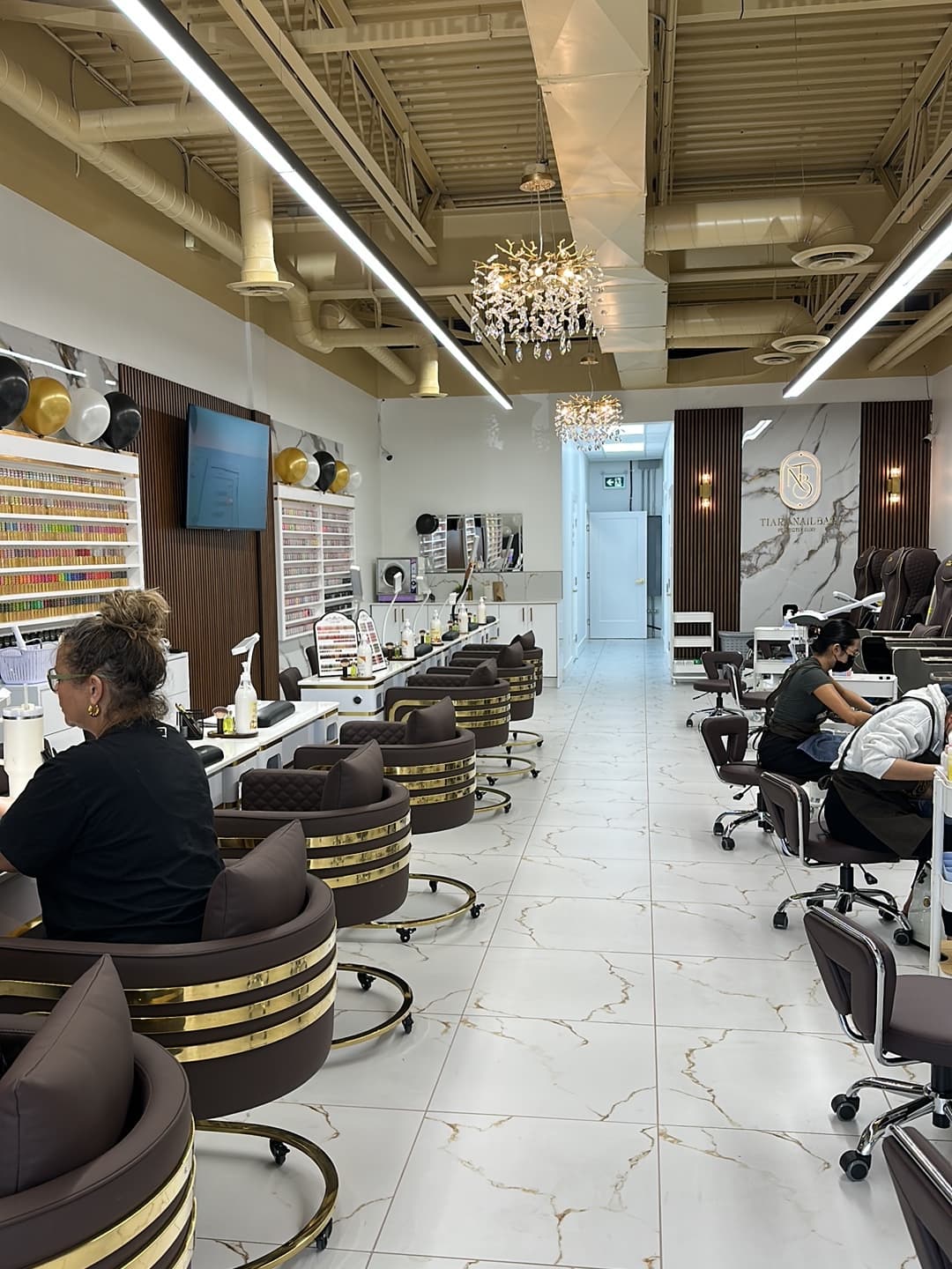 Manicure stations with quilted leather chairs and brass details