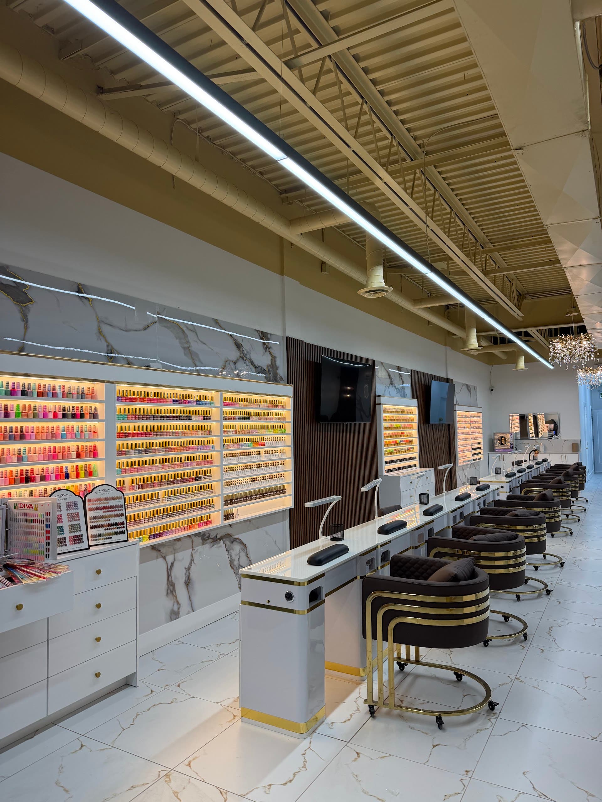 Backlit wall of polish colours above marble manicure stations